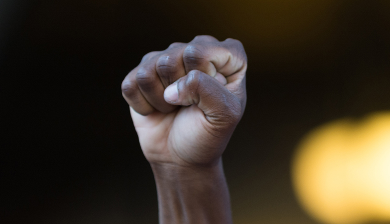 Mão negra estendida com punho fechado, símbolo do movimento negro. 